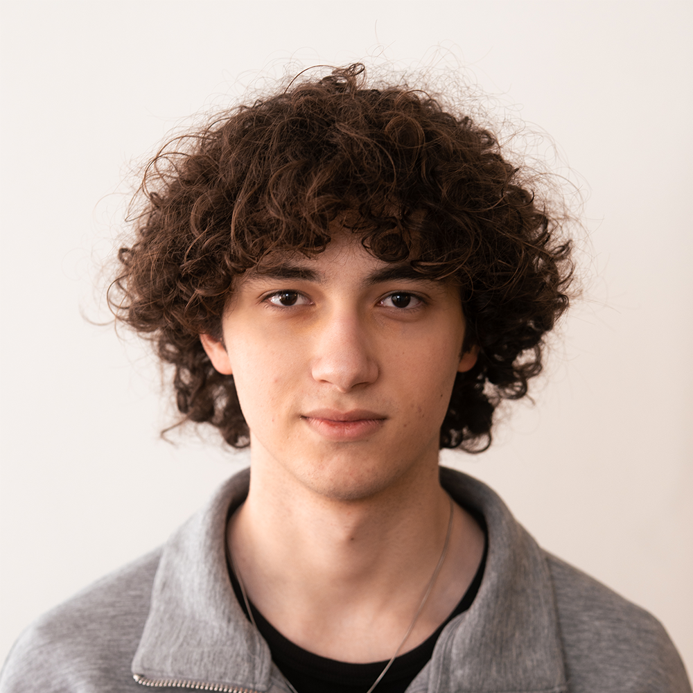 Portraitfoto von Semih Kaya vor neutralem Hintergrund