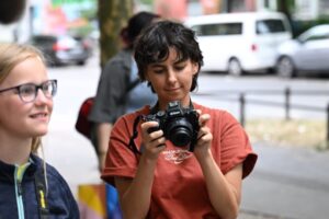 Foto von zwei Personen, eine mit Kamera in der Hand